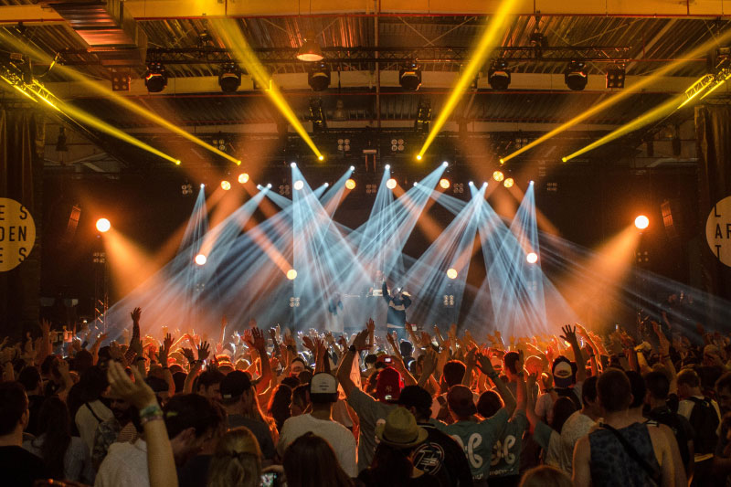 Regenbogenfahnen wehen im Vordergrund, während der Kölner Dom markant im Hintergrund zu sehen ist. Menschen sind dabei, den Cologne Pride zu feiern.Rainbow flags fly in the foreground, while Cologne Cathedral can be seen prominently in the background. People are celebrating Cologne Pride.